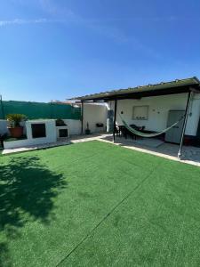 a large yard with a hammock on a patio at The Lemon Tree Villa in Charneca