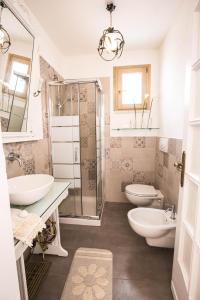 un bagno con due lavandini e una doccia e due servizi igienici di Il Borgo a Poggiardo