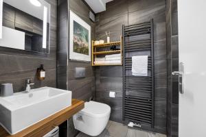 a bathroom with a white sink and a toilet at JUNIPRO Apartments Bostalsee in Bosen-Eckelhausen +51 photos
