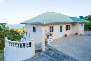 馬埃島的住宿－梅根度假屋，带阳台和车道的白色小房子