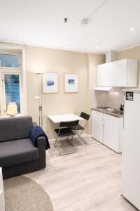 a living room with a couch and a kitchen at Liten studioleilighet meget sentralt i sentrum, 3 minutter fra torget in Trondheim