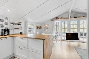 a kitchen with white cabinets and a flat screen tv at FAN026-Fano-Hedesvinget-12 in Fanø