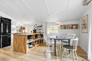 a kitchen and dining room with a table and chairs at FAN026-Fano-Hedesvinget-12 in Fanø