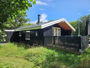 a small black house on a grass field at FAN026-Fano-Hedesvinget-12 in Fanø +38 photos