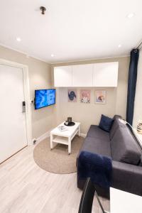a living room with a couch and a table at Liten studioleilighet meget sentralt i sentrum, 3 minutter fra torget in Trondheim