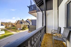 a balcony with two chairs and a view of a street at JUNIPRO Apartments Bostalsee in Bosen-Eckelhausen