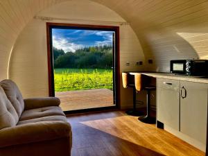 a room with a kitchen with a large window at Glamping pod with en-suite & underfloor heating in Haverfordwest