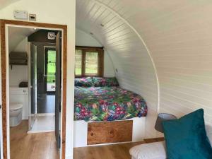 a bedroom with a bed in a small room at Glamping pod with en-suite & underfloor heating in Haverfordwest