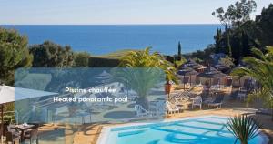 a swimming pool with chairs and umbrellas and the ocean at Hôtel & Spa Les Mouettes in Argelès-sur-Mer