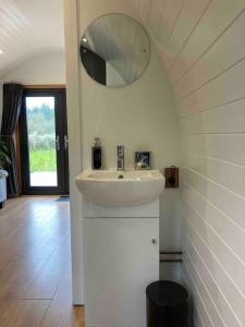 a bathroom with a sink and a mirror at Glamping pod with en-suite & underfloor heating in Haverfordwest