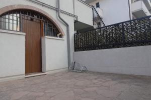 a building with a wooden door and a balcony at Volta B&B Imola in Imola