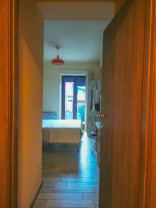 a hallway with a bedroom and a bed and a door at Locanda Ponte Rosa in Garessio