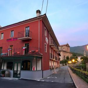a red building on the side of a street at Locanda Ponte Rosa in Garessio +4 photos