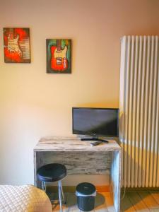 a desk with a television and two stools in a room at Locanda Ponte Rosa in Garessio