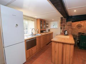 a kitchen with a white refrigerator and wooden cabinets at Plush Cottage in Dorchester