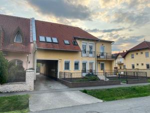 a large house with a driveway in front of it at Johanna Apartman in Harkány