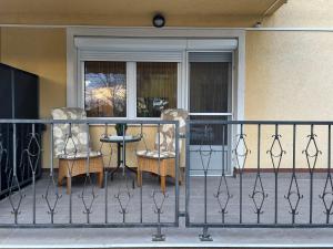 two chairs and a table on a balcony at Johanna Apartman in Harkány +9 photos