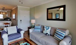 a living room with a couch and a mirror at Vibrant gulf condo with pool and beach access in Pensacola Beach