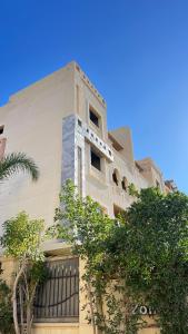 a tall building with trees in front of it at Spring house in Qaryat Shākūsh
