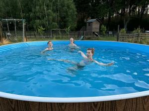 three children swimming in a large swimming pool at Chatka na Wiedźmiej Górce in Kuttlau
