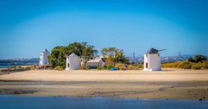 a group of three white buildings on a beach at Vieira's House in Barreiro
