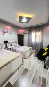 a bedroom with two beds and a ceiling with stickers at Spring house in Qaryat Shākūsh