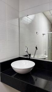 a bathroom with a large white sink and a mirror at Moda Center Hotel in Santa Cruz do Capibaribe +49 photos