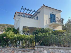 a white house with a fence in front of it at Villa Galazia in Megalochori