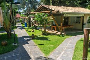 a garden with a house with a bench and trees at Pousada Reserva Penedo in Penedo