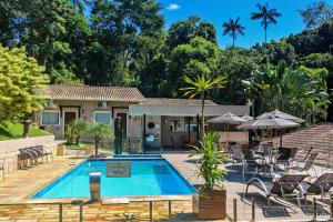 a villa with a swimming pool and a resort at Pousada Reserva Penedo in Penedo