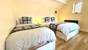 two beds in a small room withermottermottermott at La'l Stenkrith in Kirkby Stephen