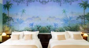 two beds in a room with a mural of palm trees at Grande Hotel Termas de Araxá in Araxá +54 photos