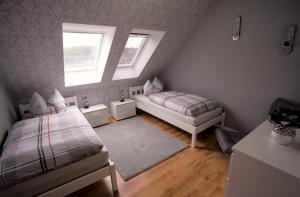 a bedroom with two beds and two windows at Zum Käutzchen 120qm Ferienhaus 8 Personen 4 Schlafzimmer in Nossentiner Hütte