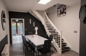 a dining room with a table and a staircase at Zum Käutzchen 120qm Ferienhaus 8 Personen 4 Schlafzimmer in Nossentiner Hütte