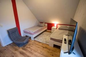 a small room with two beds and a desk with a tv at Zum Käutzchen 120qm Ferienhaus 8 Personen 4 Schlafzimmer in Nossentiner Hütte