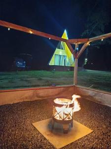 a fire pit in a backyard at night at Casutele Anei- Aframe&Spa in Rişca