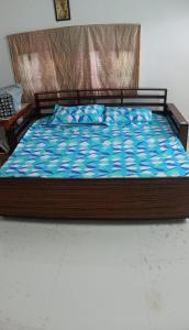 a bed with a wooden frame in a bedroom at Green Heavan Farm in Sadras