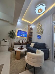 a living room with a blue couch and a table at Kai's Luxe Balcony Suite at Royal Oceancrest Mactan in Mactan Island