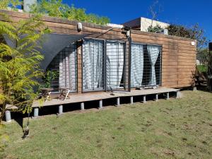 a building with a deck with windows in a yard at La Estacion Colonia in Colonia del Sacramento