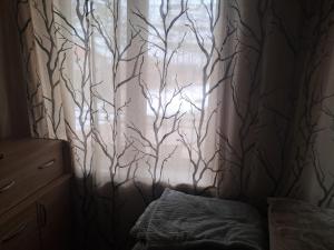 a bedroom with a window with a tree curtain at Hotel kazbegi1 in Ach'khoti