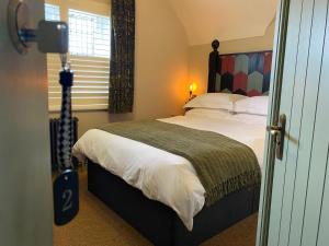 a bedroom with a large bed and a window at The Bear Tattenhall in Tattenhall