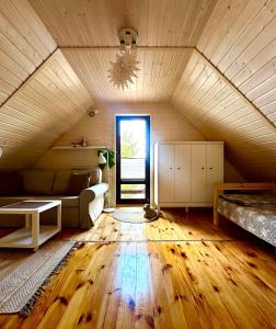 an attic room with a bed and a couch at Zatoka Kalwa in Pasym