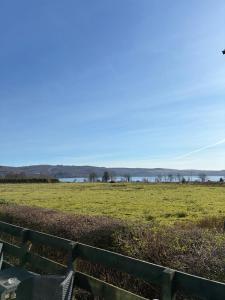 a green fence with a field in the background at Bordeaux sea view no 9 in Ardentinny