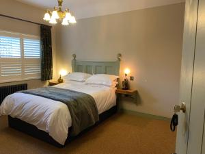 a bedroom with a bed with white sheets and pillows at The Bear Tattenhall in Tattenhall