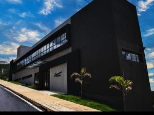 a black building with two palm trees in front of it at Pousada Varandas do Lago in Capitólio