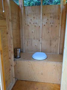 a toilet in the inside of a wooden structure at Cozy Cabin #2 in Maynooth +30 photos