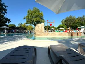 a swimming pool with a fountain in a park at Tente avec terrasse - 2 pers. - API-1-52-2040 in Grayan-et-lʼHôpital