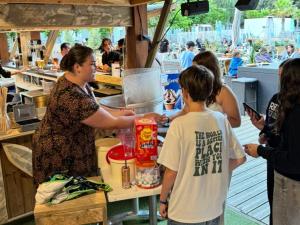 a group of people standing around a table in a kitchen at Tente avec terrasse - 2 pers. - API-1-52-2040 in Grayan-et-lʼHôpital +24 photos