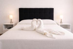 two white swans making a heart shape on a bed at Hotel RICHMOND Punta del Este in Punta del Este