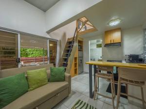 a living room with a couch and a table and a kitchen at Moorea Temae Surf Tiny House in Teavaro